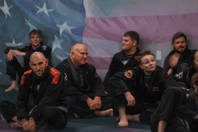 Jiu Jitsu instructors sitting in front of the American flag